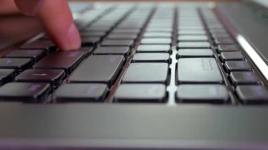 Laptop klavyesindeki tuşlara bas. Bilgisayarda çalış. Metni parmaklarınızla yazın.
