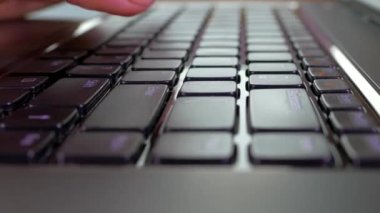 Laptop klavyesindeki tuşlara bas. Bilgisayarda çalış. Metni parmaklarınızla yazın.
