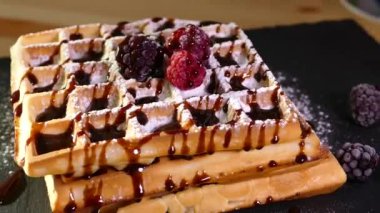 Waffle ızgarasında waffle yapmak. Hamur ve böğürtlenli tatlı. 