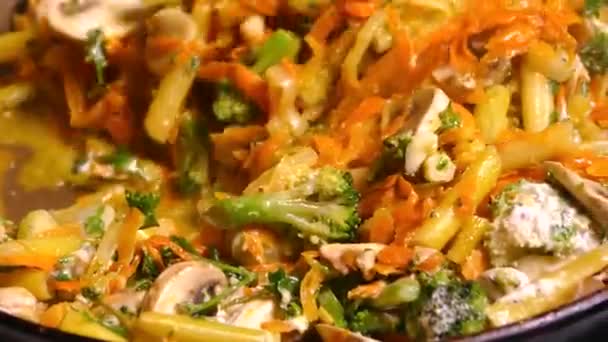 フライパンで野菜のシチューを調理します。アスパラガスの皿を攪拌,ブロッコリーとキッチンへらとキノコ.. — ストック動画