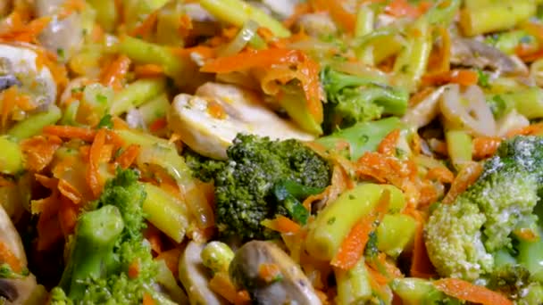 Cook vegetable stew in a skillet. Stir the dish of asparagus, broccoli and mushrooms with a kitchen spatula. — Stock Video