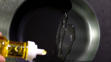 El, cam şişeden tavaya yağ döker. Zeytin yağı jeti. 