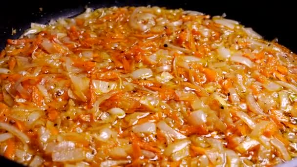 Freír la cebolla y la zanahoria en una sartén. Freír con aceite. Almuerzo de cocina en la cocina junto a la encimera. — Vídeo de stock
