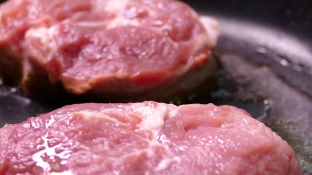 Kousek syrového masa se smaží v oleji. Vařit vepřový steak na pánvi. Připravit oběd v kuchyni. — Stock video
