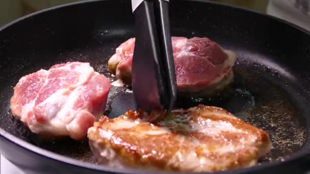 Stek biffen i en kastrull. Gör i ordning en skål med köttbitar. Fläsk med krispig skorpa närbild. — Stockvideo