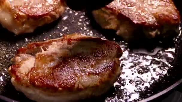 Обсмажити стейк на сковороді. Приготуйте страву зі шматочків м'яса. Свинина з хрусткою скоринкою крупним планом . — стокове відео