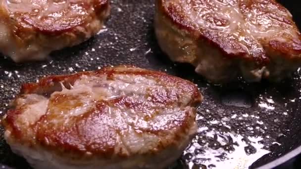 Goreng steak dalam panci. Siapkan hidangan dari potongan daging. Daging babi dengan kerak renyah close-up. — Stok Video