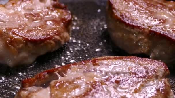 Faire frire le steak dans une poêle. Préparer un plat de morceaux de viande. Porc avec croûte croustillante gros plan. — Video