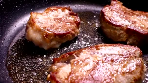 Faire frire le steak dans une poêle. Préparer un plat de morceaux de viande. Porc avec croûte croustillante gros plan. — Video