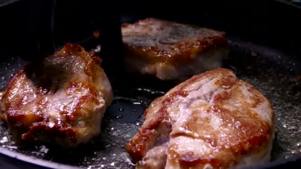 Freír el bistec en una sartén. Preparar un plato de trozos de carne. Cerdo con corteza crujiente de cerca. — Vídeo de stock