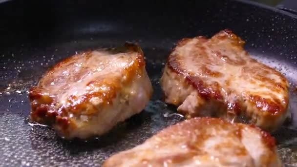 Stek biffen i en kastrull. Gör i ordning en skål med köttbitar. Fläsk med krispig skorpa närbild. — Stockvideo