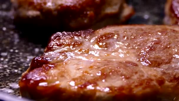 Faire frire le steak dans une poêle. Préparer un plat de morceaux de viande. Porc avec croûte croustillante gros plan. — Video