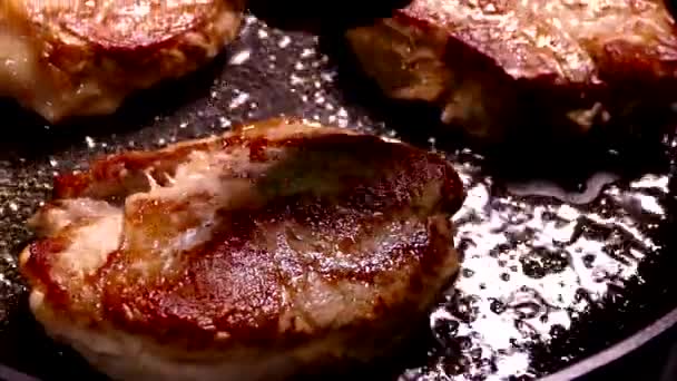 Faire frire le steak dans une poêle. Préparer un plat de morceaux de viande. Porc avec croûte croustillante gros plan. — Video