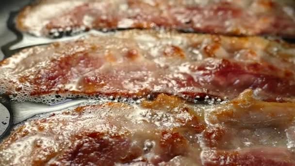 Friggere la pancetta in una padella. Una fetta di pancetta di maiale viene preparata nel suo grasso. Strato di carne e lardo. Chiudere in cucina. — Video Stock