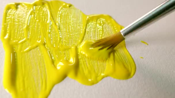 Pintura amarilla sobre lienzo. Manchar pintura al óleo sobre un lienzo de arte blanco con un pincel. — Vídeo de stock