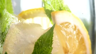 Buzlu meşrubat. Limonlu mojito ve bardakta nane. Karbonatlı su yakın çekim. Bardakta soğuk çiy damlaları.