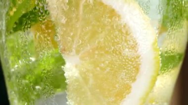 Buzlu meşrubat. Limonlu mojito ve bardakta nane. Karbonatlı su yakın çekim. Bardakta soğuk çiy damlaları.