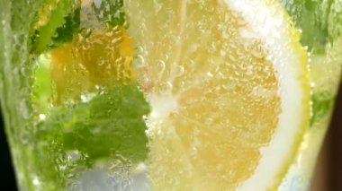 Buzlu meşrubat. Limonlu mojito ve bardakta nane. Karbonatlı su yakın çekim. Bardakta soğuk çiy damlaları.