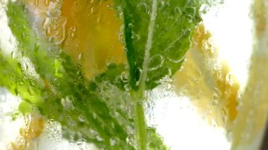 Buzlu meşrubat. Limonlu mojito ve bardakta nane. Karbonatlı su yakın çekim. Bardakta soğuk çiy damlaları.