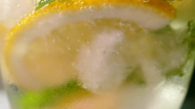 Buzlu meşrubat. Limonlu mojito ve bardakta nane. Karbonatlı su yakın çekim. Bardakta soğuk çiy damlaları.