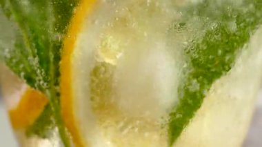 Buzlu meşrubat. Limonlu mojito ve bardakta nane. Karbonatlı su yakın çekim. Bardakta soğuk çiy damlaları.