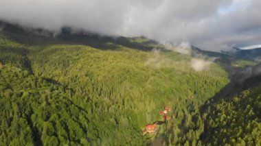 Dağlık arazinin manzaraları. Dağlar ve kozalaklı ormanlar. Dağlarda bulutlar.