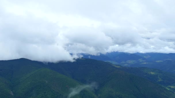Paisajes de las tierras altas. Montañas y bosques de coníferas desde una altura. Nubes en las montañas. — Vídeos de Stock