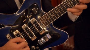 Adam gitar çalıyor.