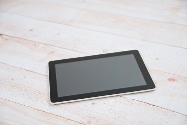 Ahşap masa üzerinde siyah dijital tablet