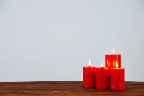 Candles on wooden table and white wall — Stock Photo, Image