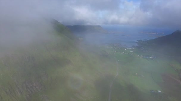 Flygande i molnen ovan grön jordbruksmark på Lofoten — Stockvideo