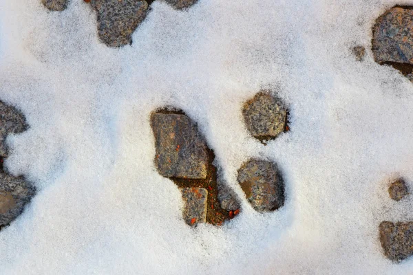 Descongelamento de neve. Fundo de neve e blocos de pedra . — Fotografia de Stock