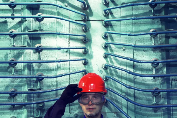 O funcionário em um capacete em fábrica . — Fotografia de Stock