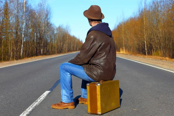 Viaje a las vacaciones. Viaje a un fin de semana.El hombre en jeans con una maleta . — Foto de Stock