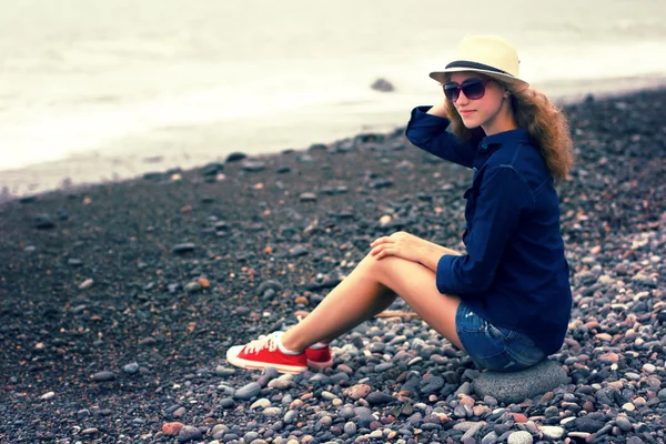 在海滩上的一顶帽子的年轻金发女郎 — 图库照片