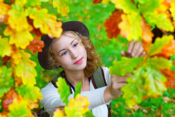 La mujer joven hermosa en el follaje otoñal. Un retrato romántico — Foto de Stock