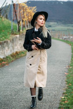 Sonbahar zamanı parkta gezen moda sarışın kadın.