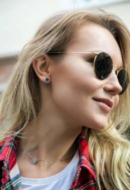 Güneş gözlüklü güzel bir sarışın kız portresi.