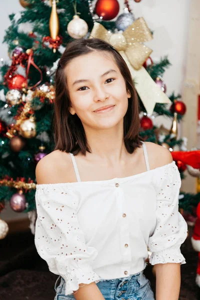 美しい十代の少女12歳のクリスマスツリーの下でクリスマスプレゼントと座っている 部屋の床に座って — ストック写真
