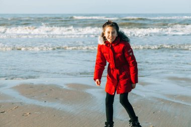 12 yaşında bir çocuk kumsalda eğleniyor. Kışın dışarıda oynayan bir çocuk.