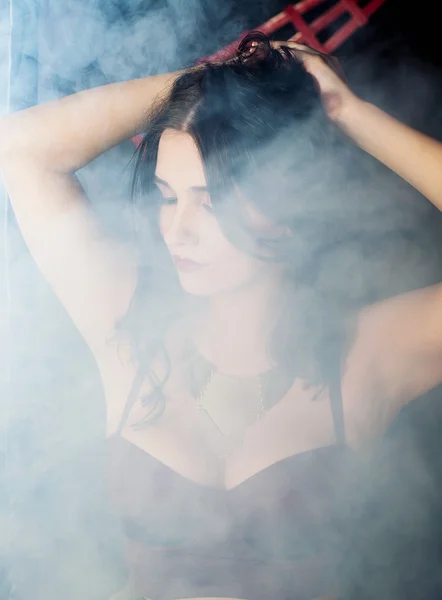 Jovem mulher bonita na fumaça — Fotografia de Stock