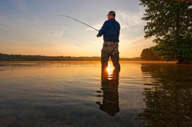 Balıkçı gün doğumunda balık yakalar.