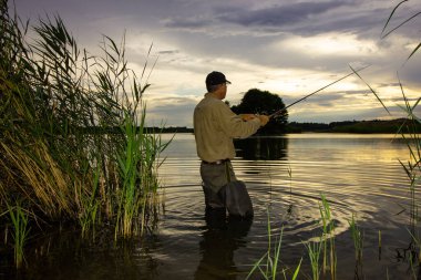 Bulutlu bir günde gölde balık tutan balıkçılar.