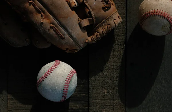baseball ball and gloves on wooden background, top view