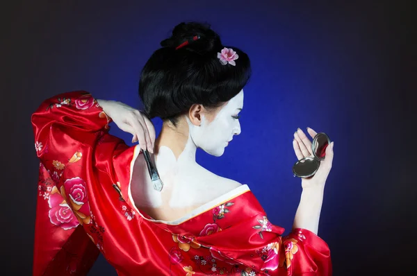 Chica aplicando maquillaje geisha — Foto de Stock