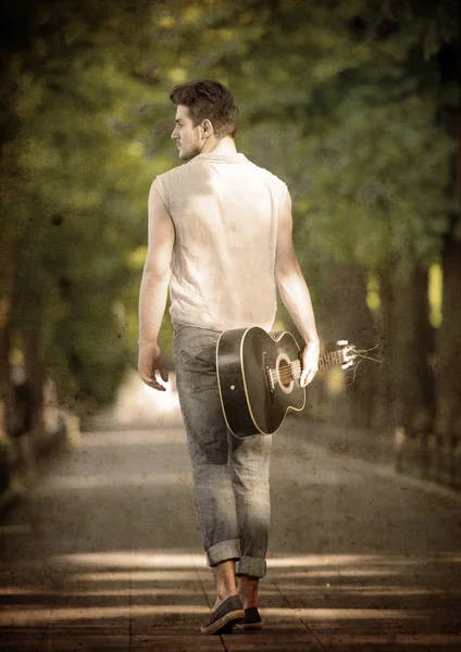 Walking man with a guitar — Stock Photo, Image
