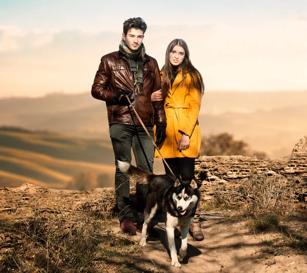 Casal caminhando seu cão — Fotografia de Stock