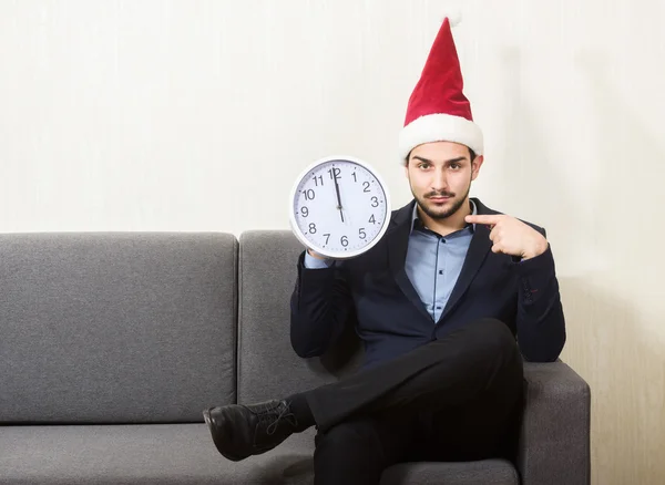 Homem de chapéu de Pai Natal apontando para o relógio — Fotografia de Stock