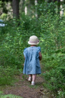 İsveç ormanlarında ormanda yürüyen genç bir kız.