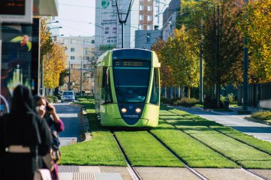 Fransa 'yı 31 Ekim 2020' de, Fransa 'nın Grand Est bölgesindeki bir şehir olan Reims toplu taşıma sisteminin bir parçası olan caddelerden geçen yolcular için modern bir elektrikli tramvaya bakıyor.